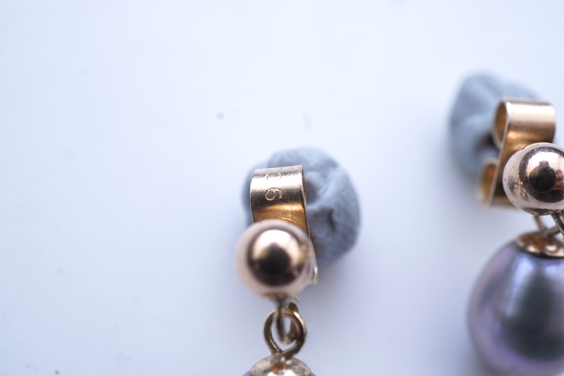 A group of cultured pearl jewels, comprising: two pairs of cultured pearl drop earrings, longest 3cm, mounted in gold; and two cultured pearl brooches mounted in 9ct gold, longest 4.1cm, British hallmarks, combined gross